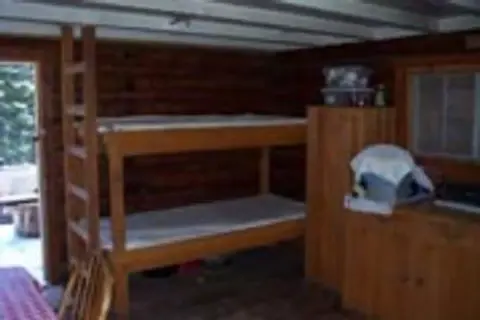 A rustic wooden interior with bunk beds and wooden furniture.