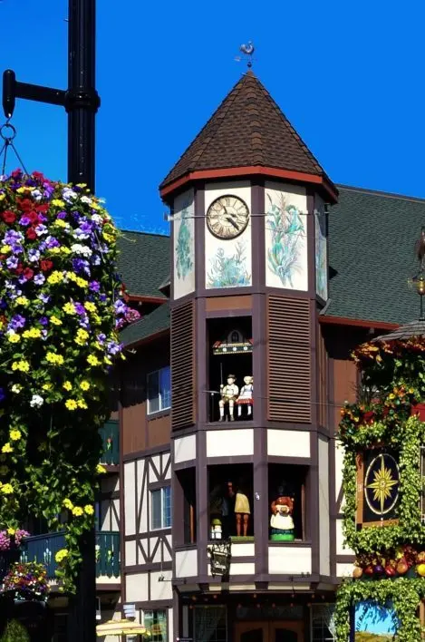 A detailed clock tower with figures and painted decorations on a building facade.