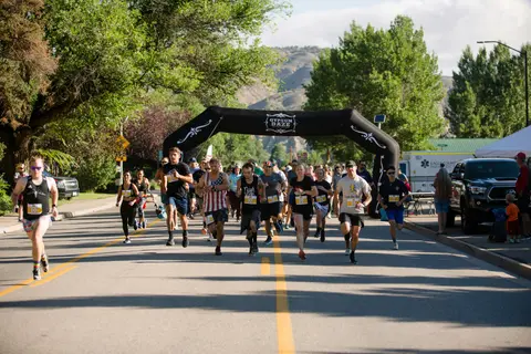 A group of runners participate in a race on a street.