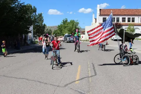 People riding bicycles and walking in a street with an American flag.