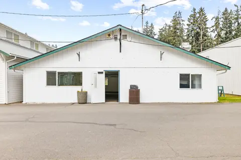 An exterior view of a white single-story building with a pitched roof.