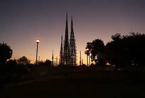 A tall towers sculpture silhouetted against a sunset sky.