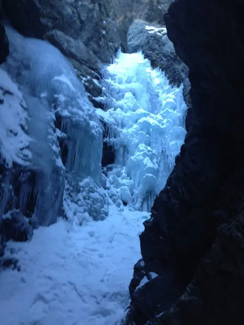 A frozen waterfall inside a rocky canyon.