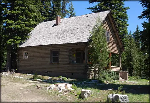 A log cabin nestled among evergreen trees.
