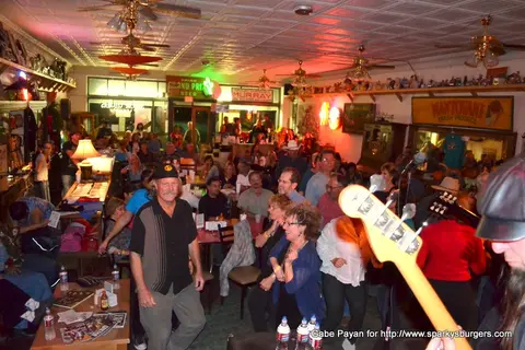 A crowded interior venue filled with people enjoying a performance.