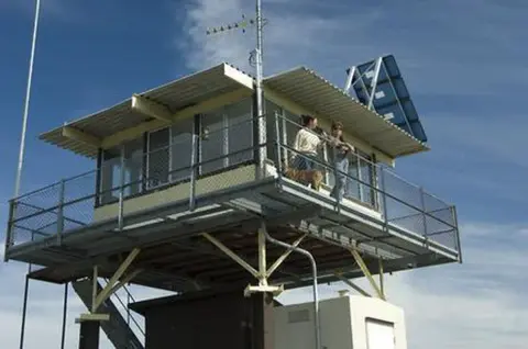A photo of a lookout tower with people standing on the balcony.