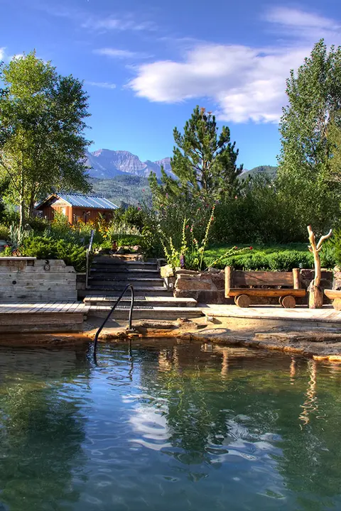 An outdoor hot spring pool with mountains in the background.
