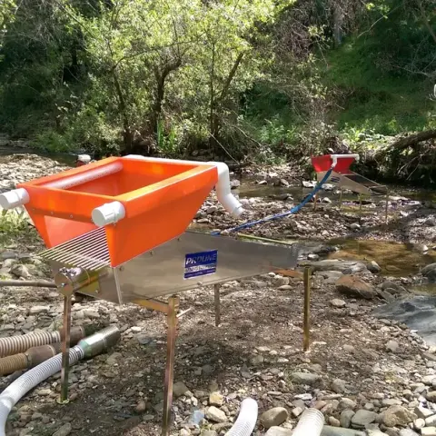 Mining equipment set up near a stream.