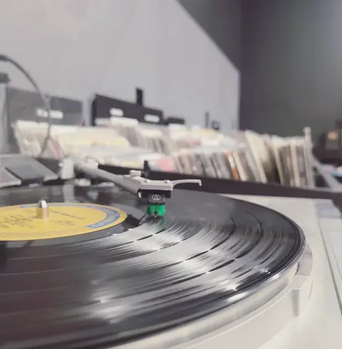 A record player plays a vinyl record in a record store.