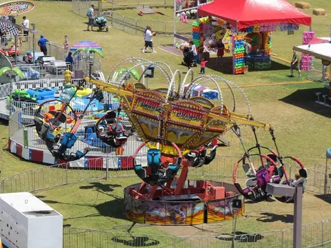 An overhead view of an outdoor carnival with colorful rides and visitors.