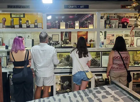 Four people look at displays in a museum exhibit.