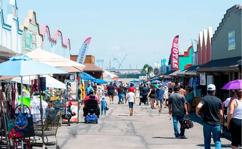 A wide view of a busy outdoor market street lined with shops and vendors.