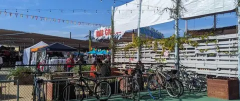 Bicycles are parked in front of an outdoor market venue.