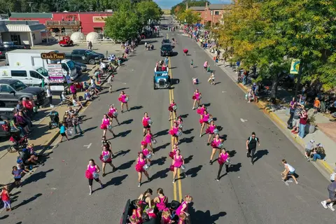 An aerial view of a parade with cheerleaders walking down a street.