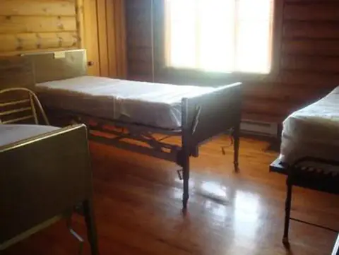 A photo showing the interior of a room with several beds.
