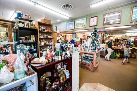 The inside of an antique shop filled with various items and shoppers.