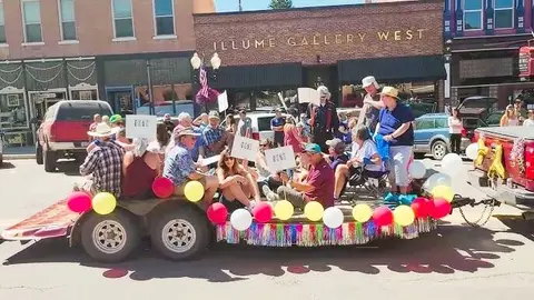 A parade float filled with people riding down a street.