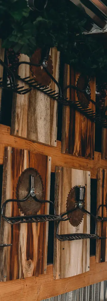 Wooden panels decorated with vintage saw blades and metal rake heads.