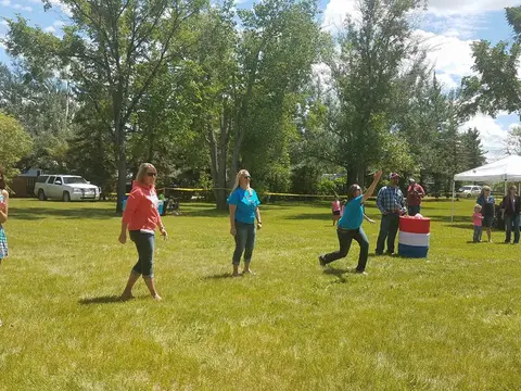People playing a yard game on a grassy lawn.