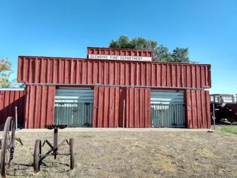 A red building with a fire department sign stands outdoors.