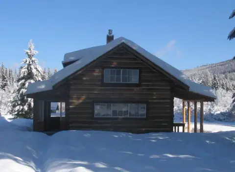 A log cabin covered in snow during winter.