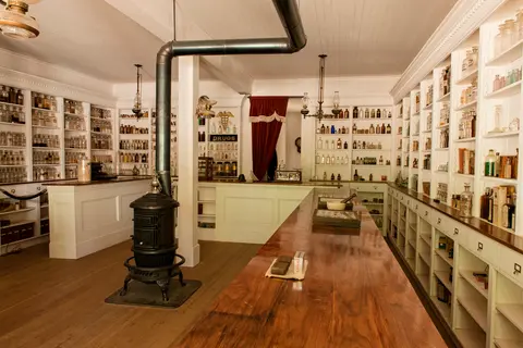 A historic interior of an old apothecary shop with shelves filled with bottles.