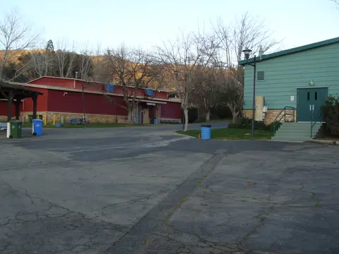 An outdoor paved area between two buildings with bare trees.