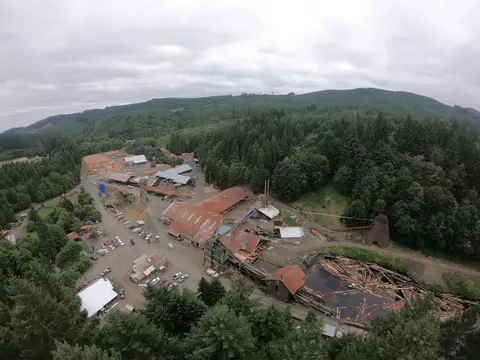 An aerial view of a timber mill nestled in a wooded valley.