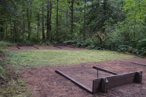 Horseshoe pits in a clearing surrounded by trees.