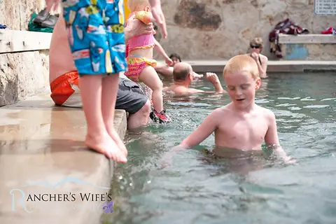 People swimming and wading in a pool.