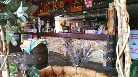 An interior view of a winery tasting room with a bar, wine bottles, and decorative items.