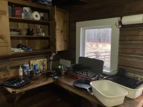 This photo shows the interior kitchen of a rustic log cabin.
