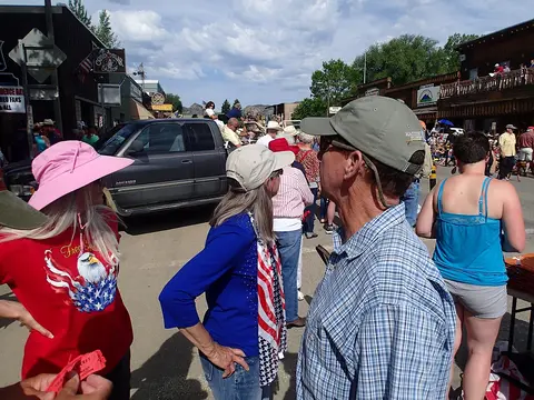 A crowd of people gathers outside on a sunny day.