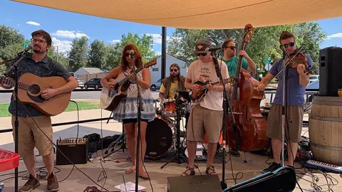 A band playing music outdoors under a canopy.