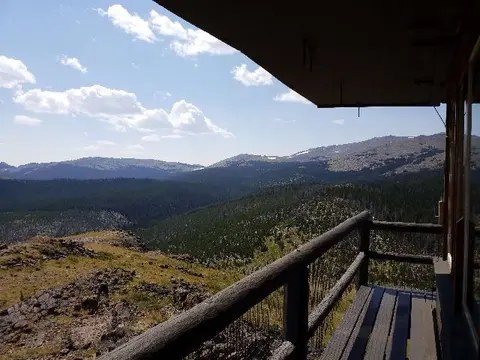 A view of mountains and forests from a balcony.