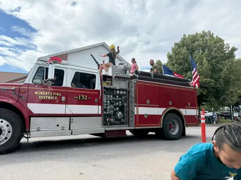 A red and white fire engine is parked outside.