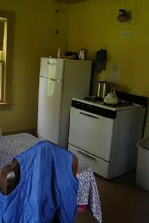 Interior view of a kitchen with a white refrigerator and stove.