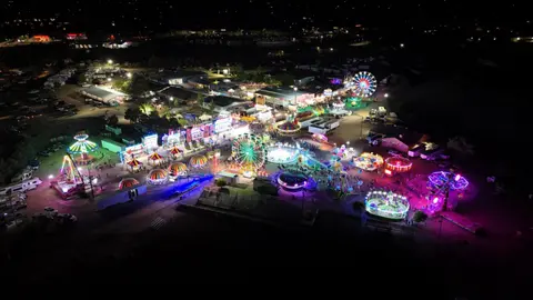 An aerial view of a brightly lit carnival at night.