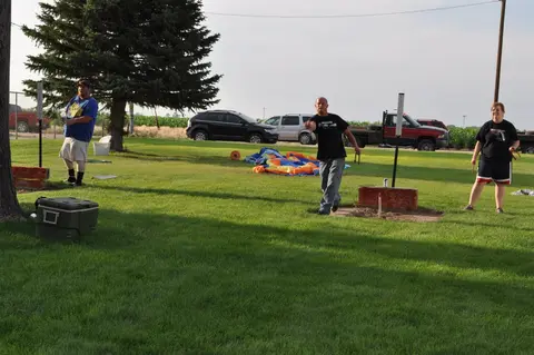 People playing a lawn game on a grassy field.