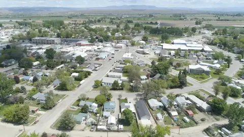 An aerial view of a small town with houses and buildings surrounded by fields.