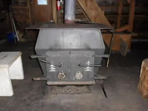 A wood burning stove sits inside a room.