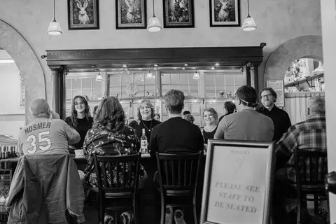 Interior view of people seated at a bar counter.