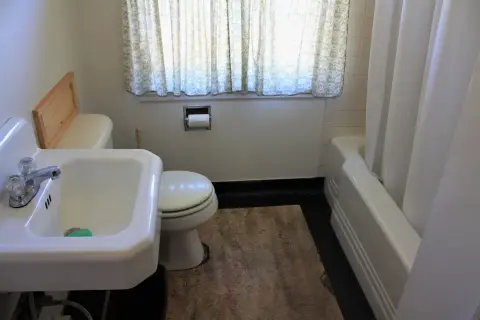 An interior view of a bathroom showing a sink, toilet, and bathtub.