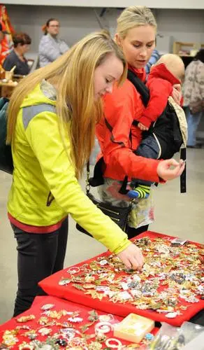 People looking at items on a display table at an event.