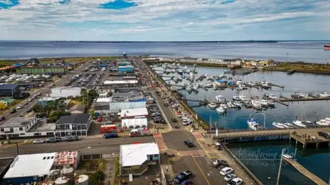 An aerial view of a harbor town next to the sea.