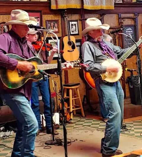 A band performs country music on an indoor stage.