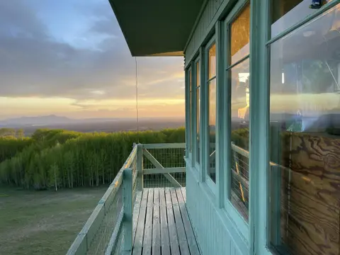 A view from the balcony of a fire lookout tower at sunset.