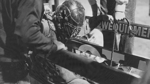 A person wearing a protective helmet prepares inside a chute.