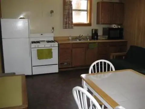 A view of an indoor kitchen with appliances and a dining table.