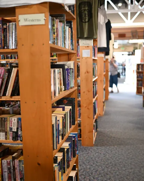 A photograph showing rows of wooden bookshelves inside a bookstore.